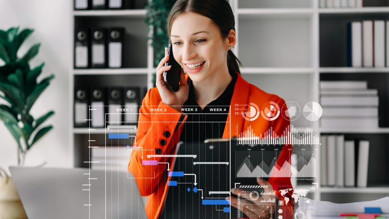 woman in orange jacket talking on cell phone in office with diagrams